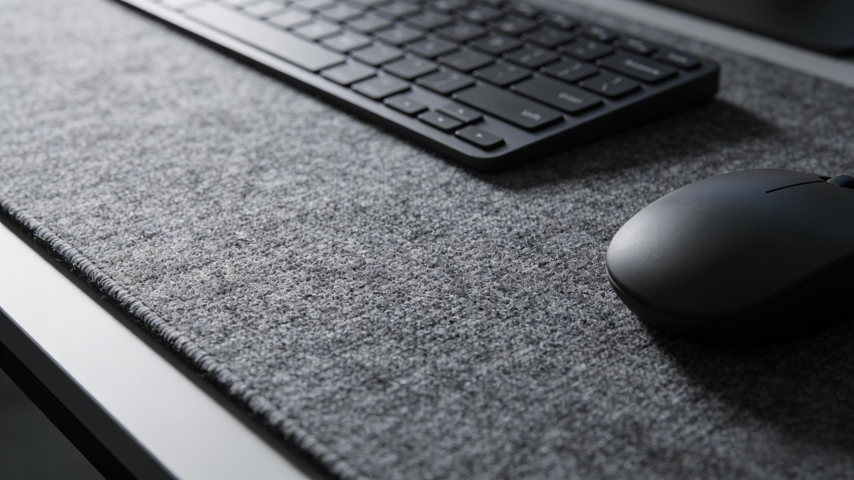 Close-up of a microfiber fabric desk mat showing fine woven texture for accurate mouse tracking